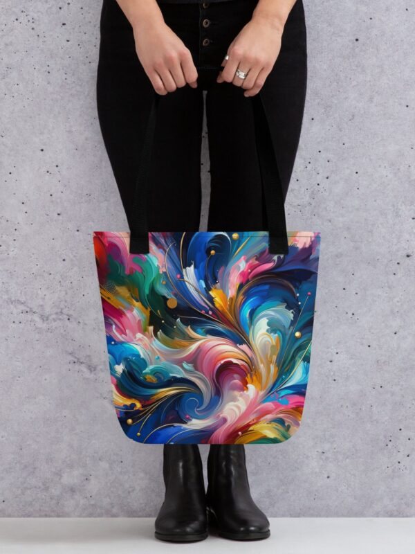 A vibrant and colorful tote bag, named the Cosmic Dance Tote Bag, displays a dazzling array of hues in an abstract, cosmic-inspired pattern. The rich, swirling colors suggest a celestial theme, reminiscent of a galaxy's dynamic beauty.