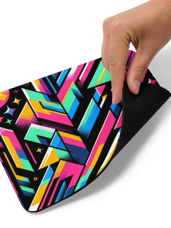 A hand resting on a ZestFiesta Mouse Pad, which displays a vivid geometric pattern in bright shades of pink, blue, yellow, and black, providing a colorful and dynamic surface for mouse usage.