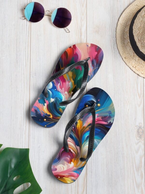 A pair of colorful flip-flops with a vibrant abstract design is laid on a white wooden surface. Next to the flip-flops are a pair of round purple-tinted sunglasses and a straw hat, suggesting a summer theme.