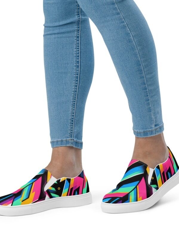 Colorful abstract geometric-patterned slip-on sneakers with a black canvas upper, bright pink, blue, and yellow shapes, elastic side accents for easy wear, and a contrasting white rubber sole for superior comfort and traction.